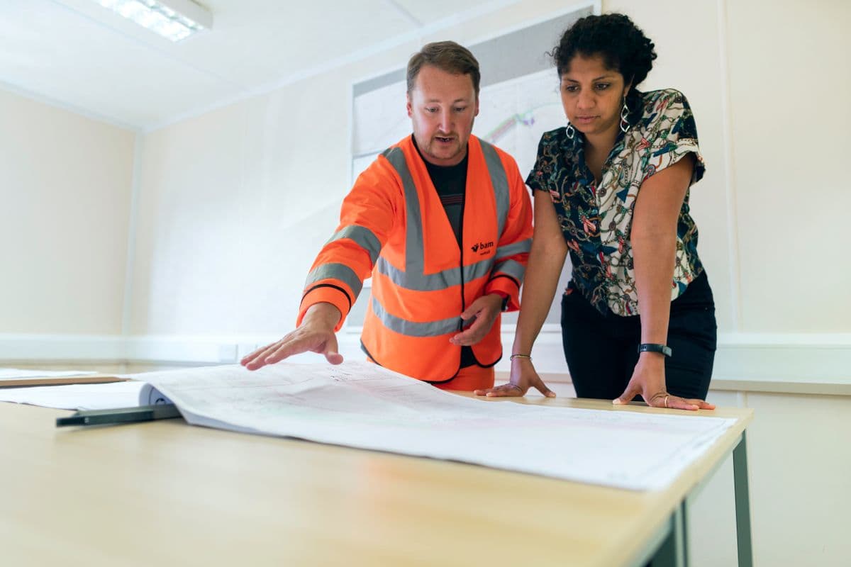 Two engineers reviewing plans together on-site