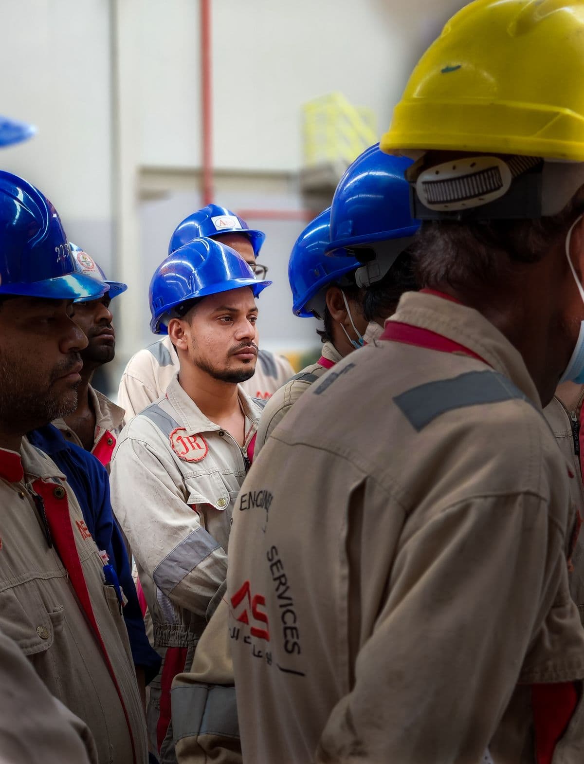 A team of workers in hard hats gathered for a safety briefing